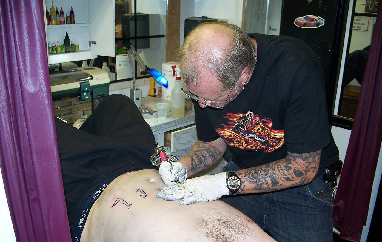 Tatuador trabajando en La Bella Época Tattoo & Piercing